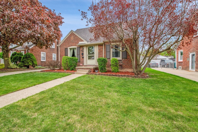 bungalow featuring roof with shingles, a front lawn, and brick siding