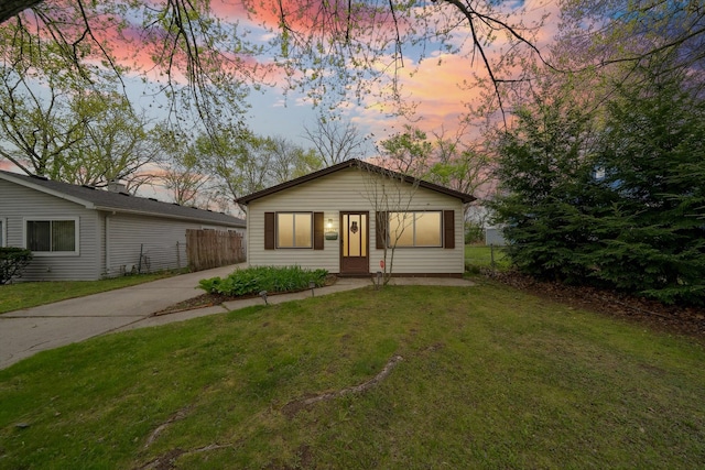 view of front of house featuring a lawn and fence
