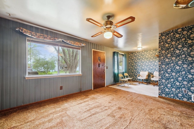interior space featuring carpet floors, wallpapered walls, baseboards, and ceiling fan