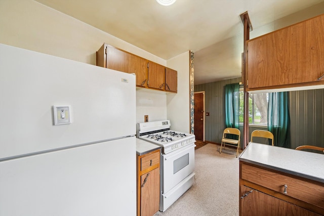 kitchen featuring light countertops, light carpet, white appliances, and brown cabinetry