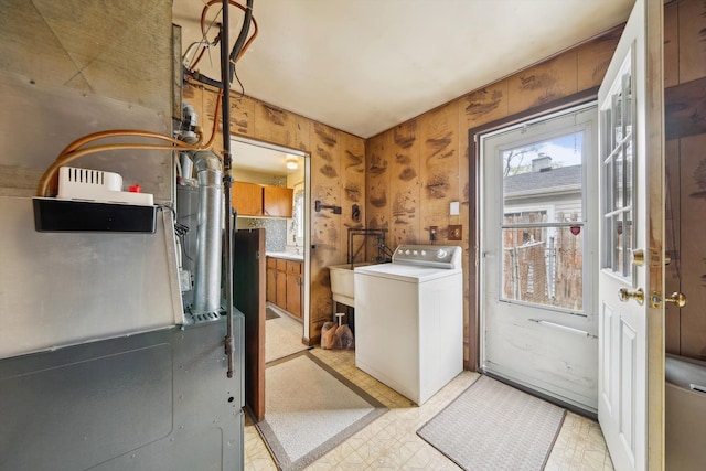 washroom with laundry area, washer / dryer, heating unit, and light floors