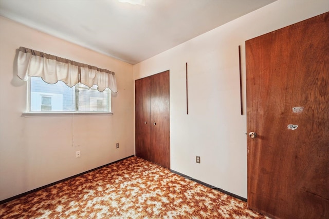 unfurnished bedroom featuring carpet flooring, baseboards, and a closet