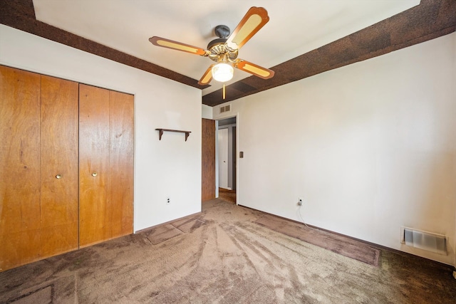 unfurnished bedroom featuring a closet, a ceiling fan, carpet flooring, and visible vents