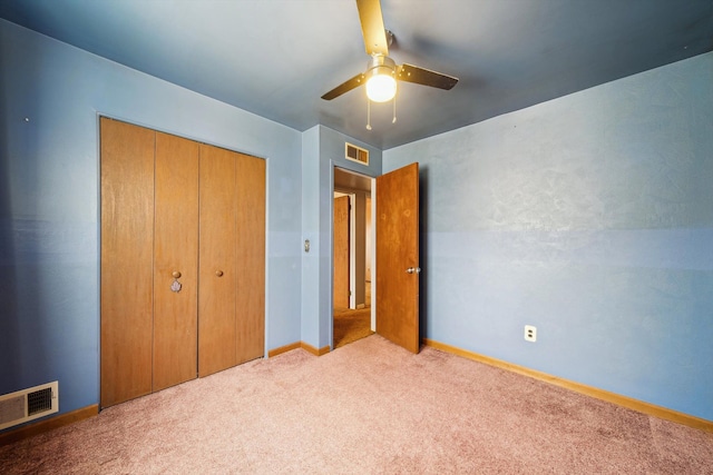 unfurnished bedroom featuring visible vents, carpet, baseboards, and a closet