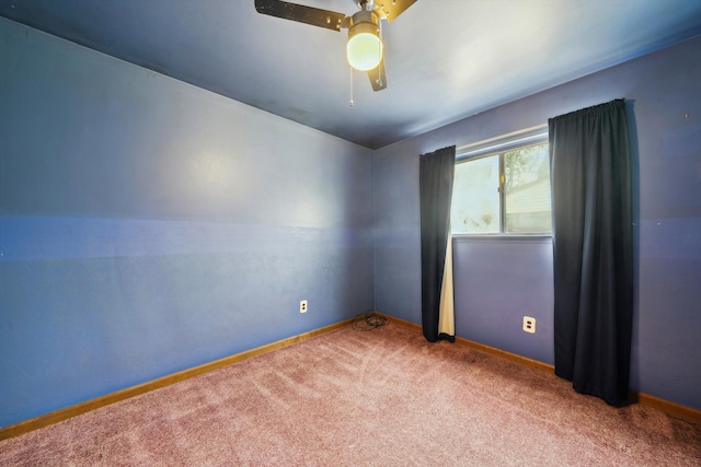 carpeted spare room featuring baseboards and ceiling fan