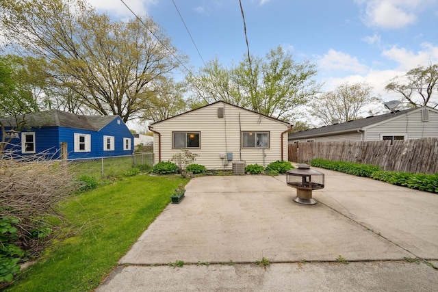 rear view of house featuring a patio, a fenced backyard, a yard, and cooling unit