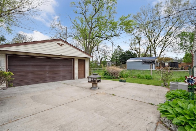 detached garage featuring fence and cooling unit