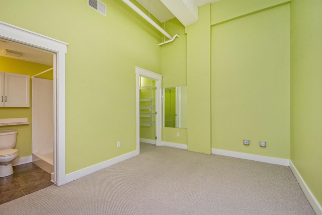 interior space featuring carpet flooring, baseboards, and visible vents