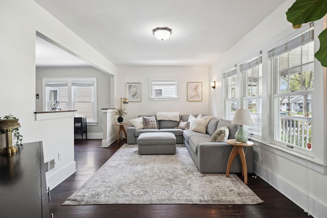 living area with visible vents, baseboards, and dark wood-style floors