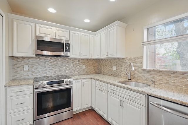 25030 Sherwood Cir, Southfield, MI 48075 - kitchen featuring dark wood-style flooring, white cabinetry, a sink, backsplash, and stainless steel appliances