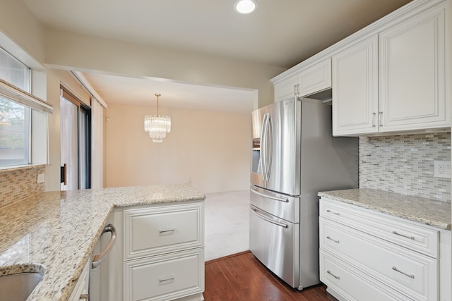 25030 Sherwood Cir, Southfield, MI 48075 - kitchen featuring a peninsula, stainless steel fridge, dark wood-type flooring, white cabinets, and tasteful backsplash