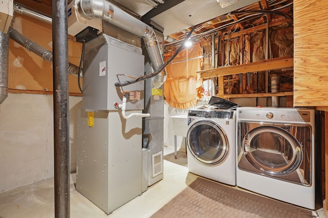 25030 Sherwood Cir, Southfield, MI 48075 - washroom featuring heating unit, separate washer and dryer, and laundry area