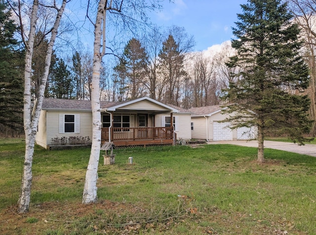 ranch-style house featuring a garage, driveway, covered porch, and a front yard