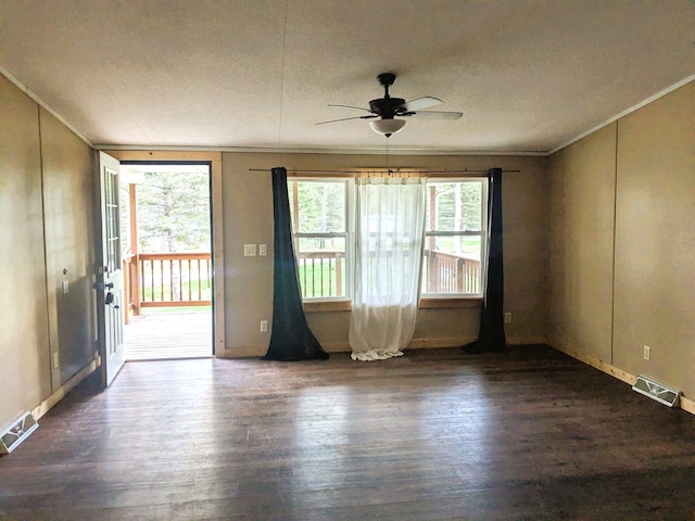 empty room featuring crown molding, ceiling fan, wood finished floors, and visible vents