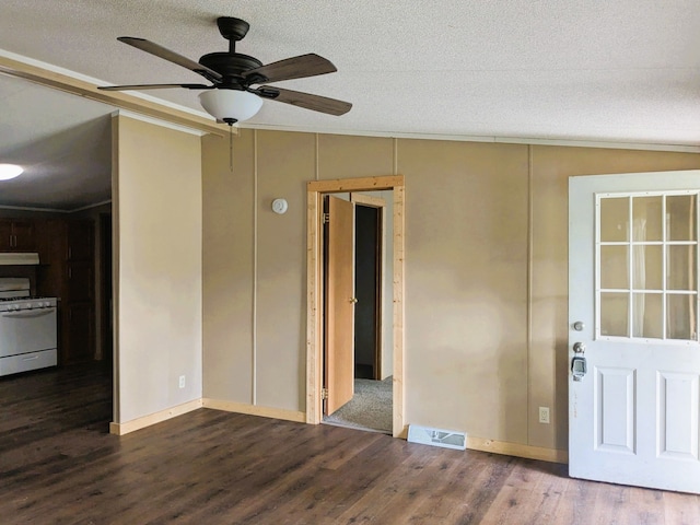 empty room with crown molding, a textured ceiling, a ceiling fan, wood finished floors, and visible vents