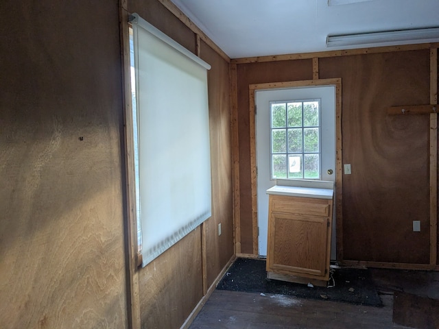 doorway featuring baseboards and dark wood-style floors