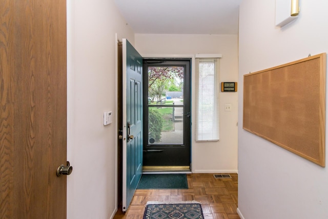 doorway featuring baseboards and visible vents