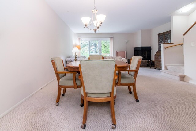 dining area with an inviting chandelier, carpet flooring, baseboards, and stairway