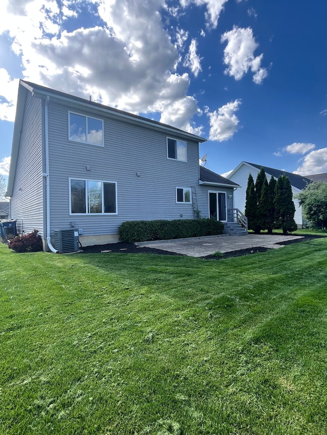 rear view of property with a patio, a lawn, and central AC