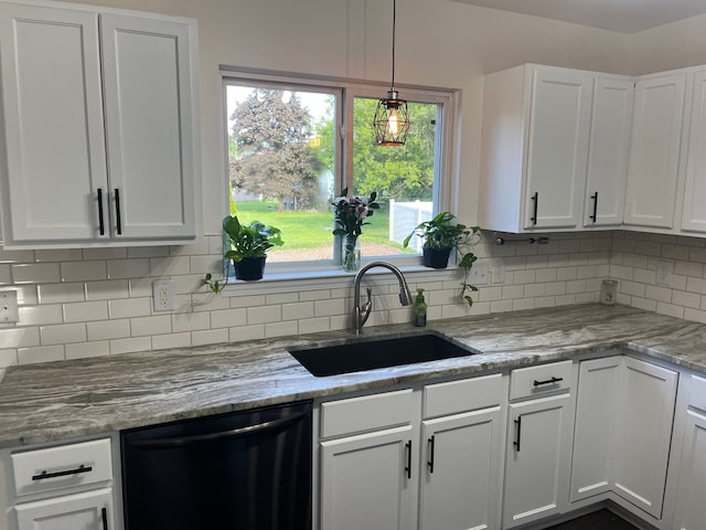 kitchen with black dishwasher, a sink, tasteful backsplash, and white cabinets