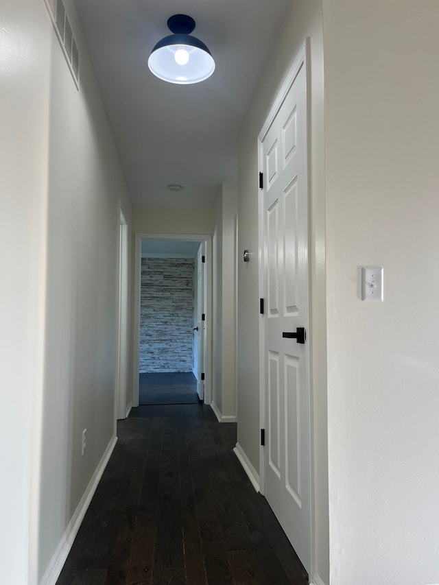 corridor featuring dark wood finished floors and baseboards