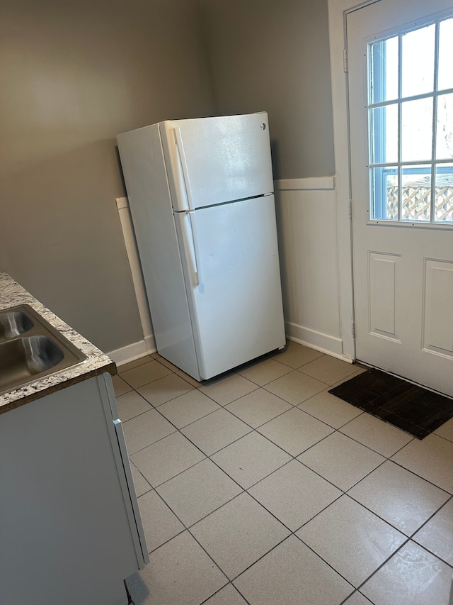 20 Thorpe St, Pontiac, MI 48341 - kitchen featuring freestanding refrigerator, a wainscoted wall, light countertops, light tile patterned flooring, and a sink