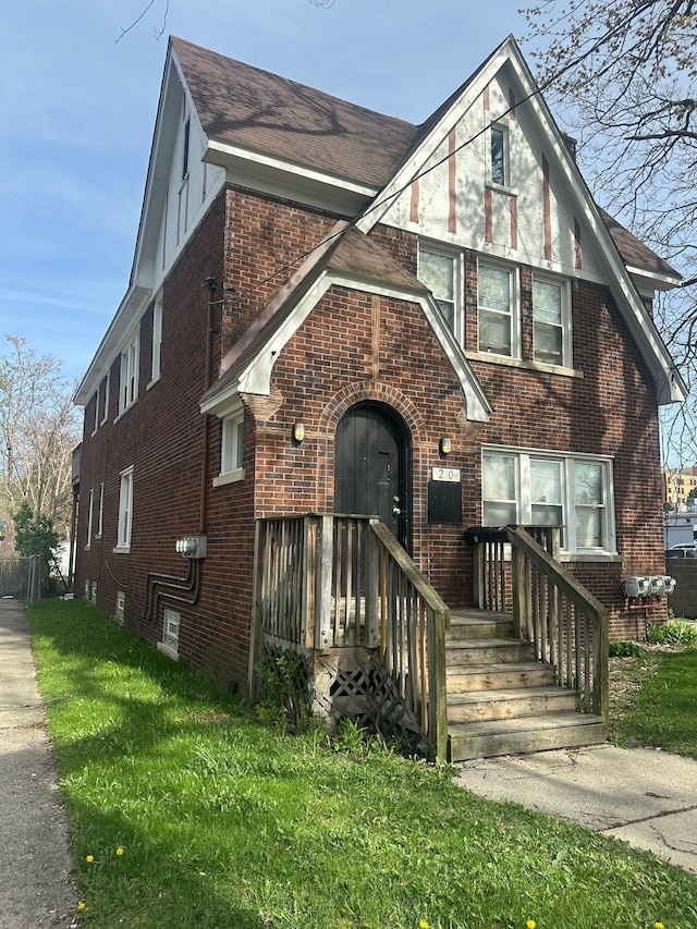 20 Thorpe St, Pontiac, MI 48341 - tudor home featuring brick siding, a front lawn, and a shingled roof