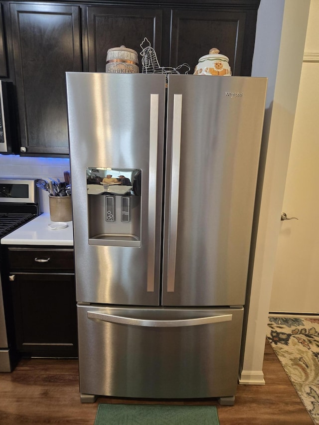 room details with light countertops, dark wood-style flooring, appliances with stainless steel finishes, and dark cabinets