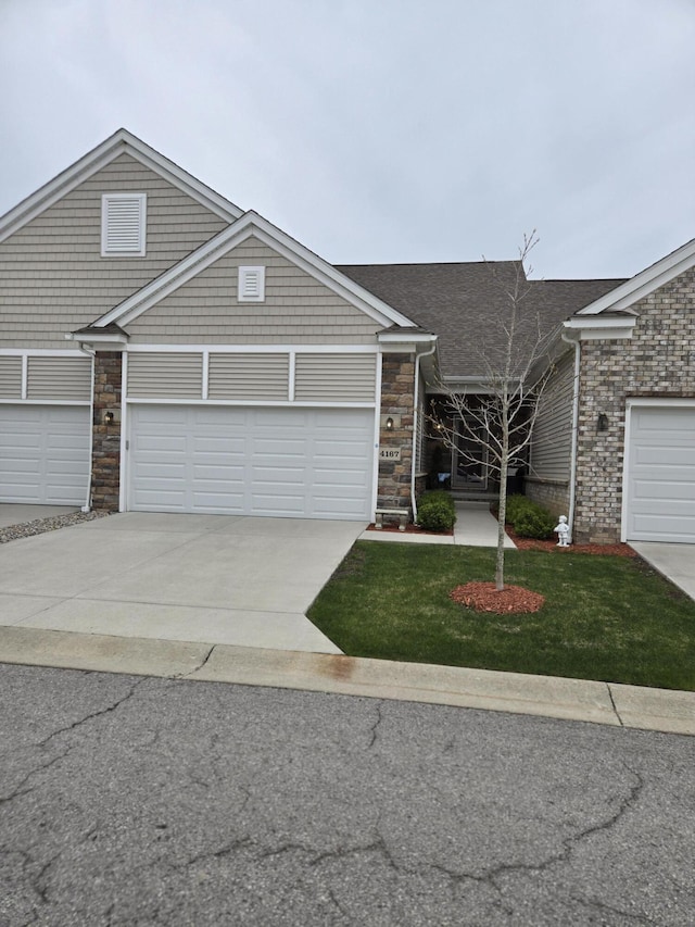 view of front of house featuring stone siding, driveway, and a front yard