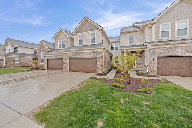 view of front facade featuring an attached garage, concrete driveway, a front yard, and stone siding