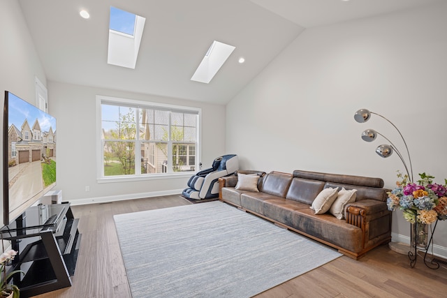 living area featuring recessed lighting, lofted ceiling with skylight, baseboards, and wood finished floors