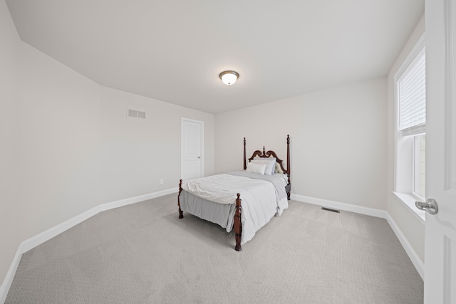 carpeted bedroom with visible vents and baseboards