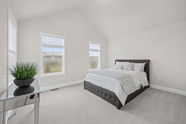 carpeted bedroom featuring vaulted ceiling, visible vents, and baseboards
