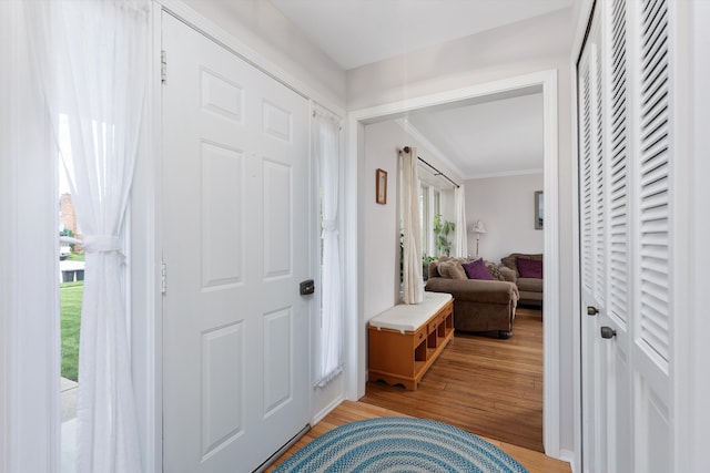 foyer featuring light wood-type flooring and ornamental molding