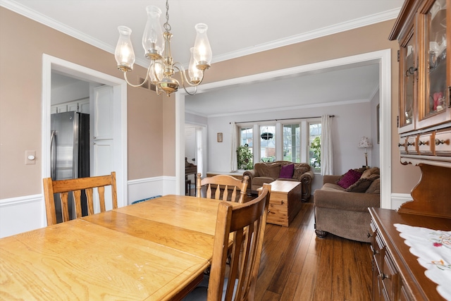 dining area featuring ornamental molding, a chandelier, and dark wood-type flooring
