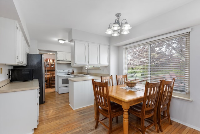 dining space with light wood finished floors, an inviting chandelier, plenty of natural light, and baseboards