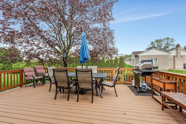 wooden terrace with outdoor dining space and grilling area