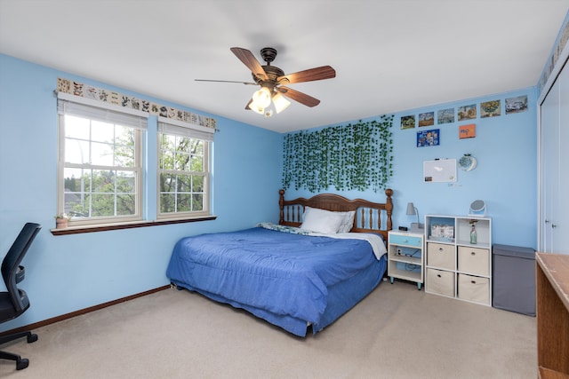 carpeted bedroom featuring a closet, baseboards, and a ceiling fan