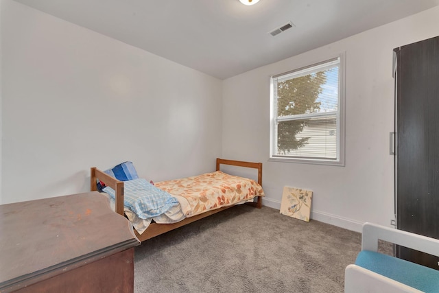 carpeted bedroom featuring baseboards and visible vents
