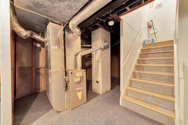 below grade area featuring heating unit and stairway