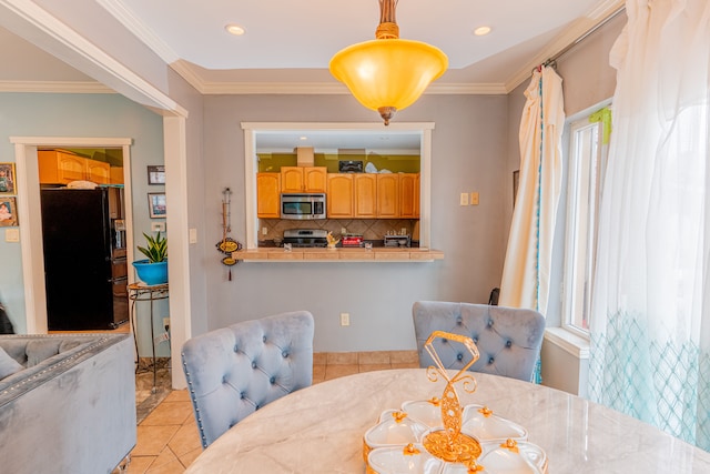 dining area featuring crown molding and light tile patterned floors
