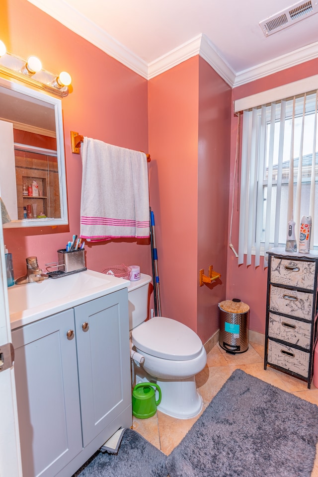 bathroom featuring tile patterned flooring, vanity, toilet, visible vents, and ornamental molding