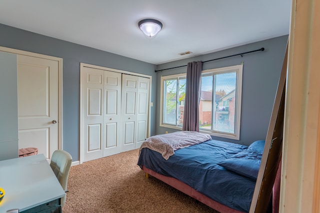 bedroom with carpet flooring, visible vents, and a closet