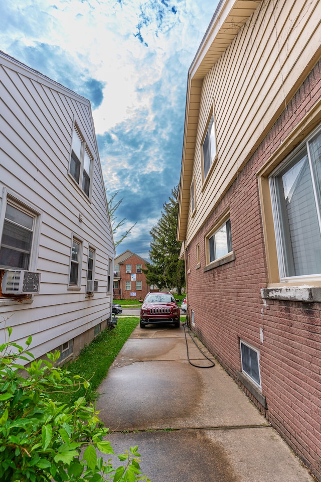 view of side of home with a residential view, cooling unit, and brick siding