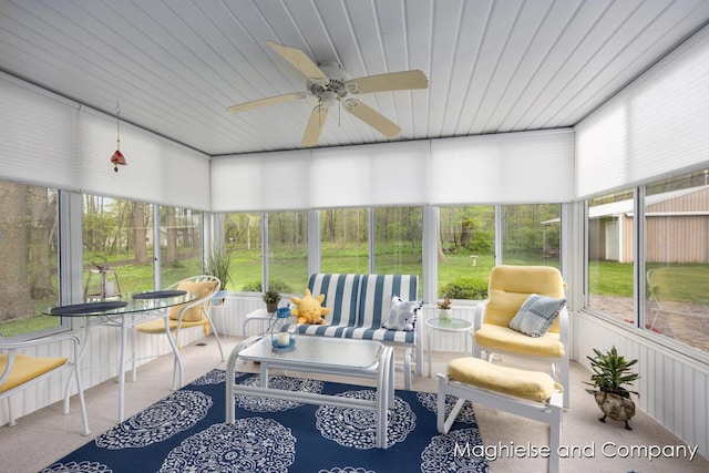 sunroom featuring a ceiling fan and an outdoor living space