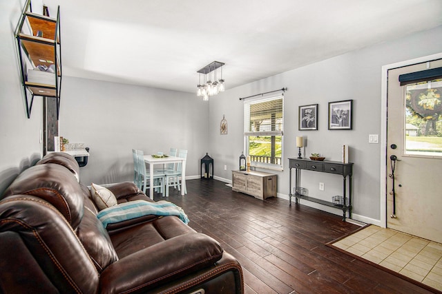 3687 Steinacker Rd, Howell, MI 48855 - living room with dark wood-type flooring, a chandelier, and baseboards