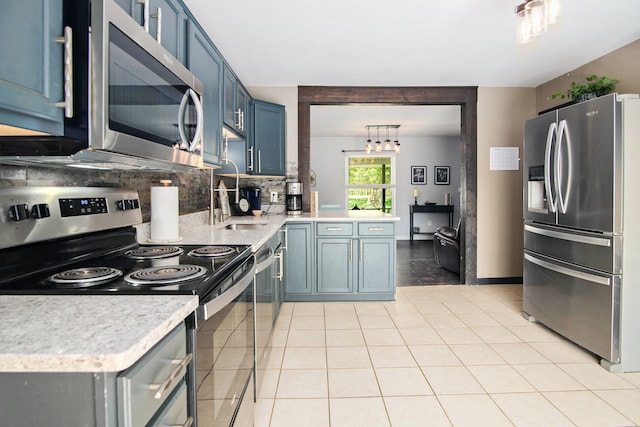 3687 Steinacker Rd, Howell, MI 48855 - kitchen with stainless steel appliances, blue cabinets, light countertops, decorative backsplash, and light tile patterned flooring