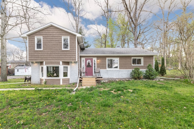tri-level home featuring brick siding and a front yard