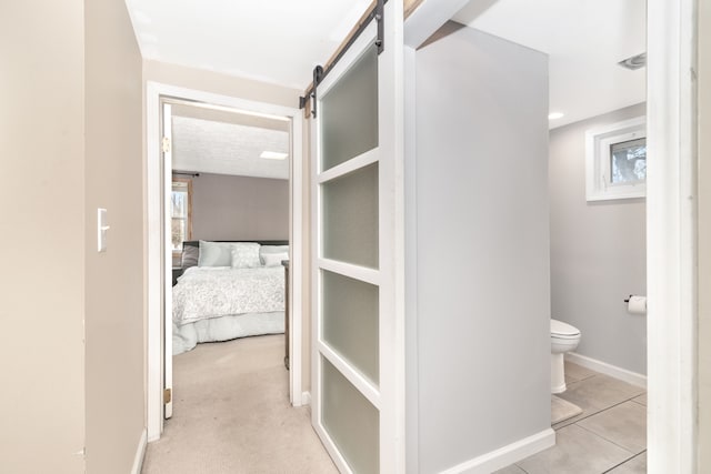 interior space featuring toilet, baseboards, and tile patterned flooring