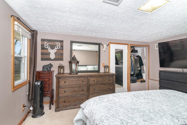 carpeted bedroom featuring a closet, a textured ceiling, visible vents, and baseboards
